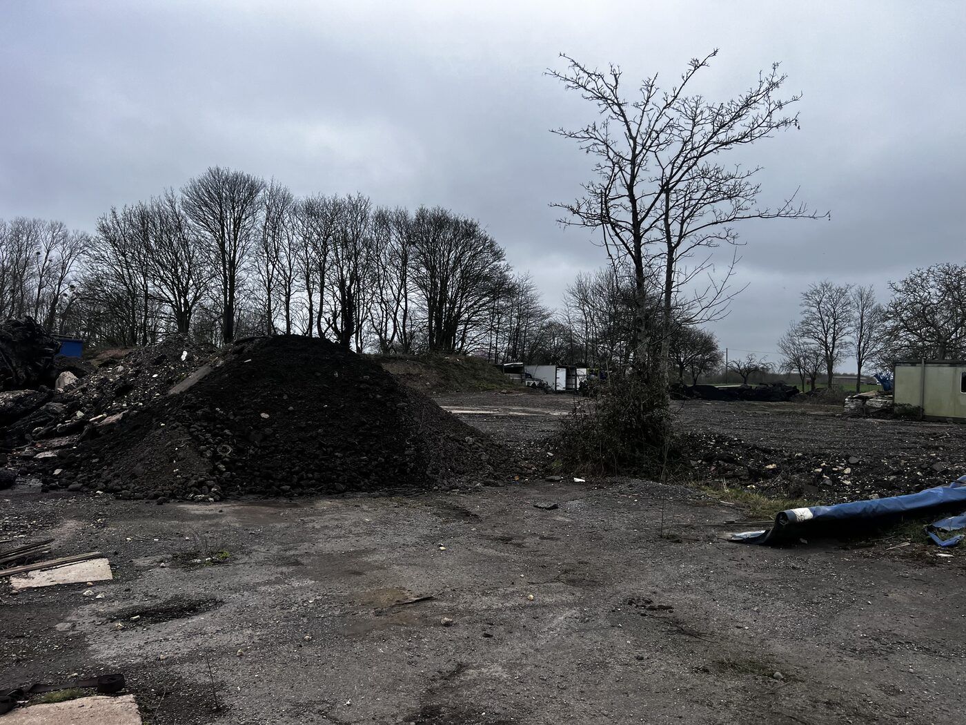 Panoramic view of large-scale fly-tipping showing multiple waste piles — active incident site 2026