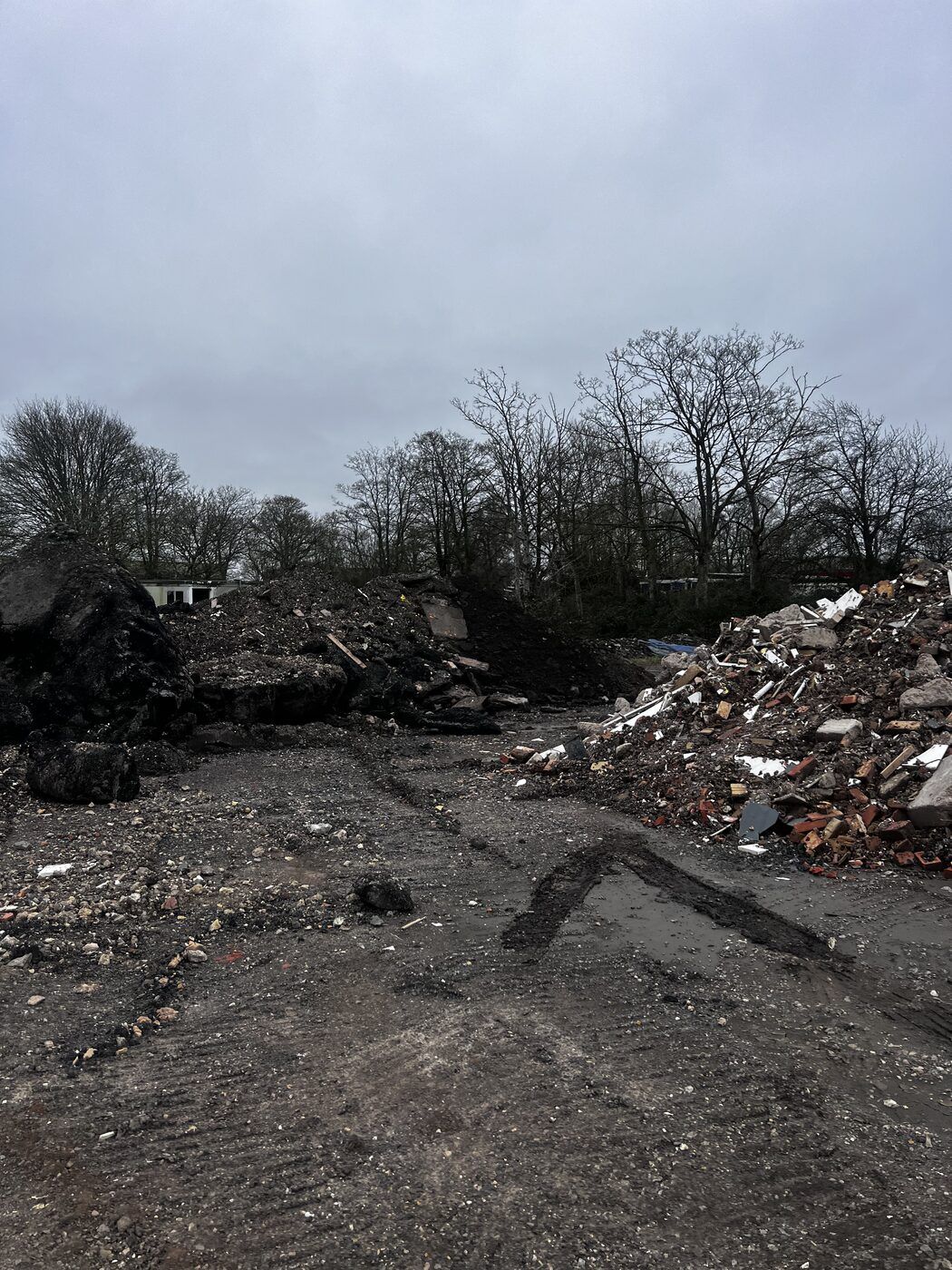 Industrial fly-tipping site showing multiple waste piles and tyre tracks — Midlands 2026